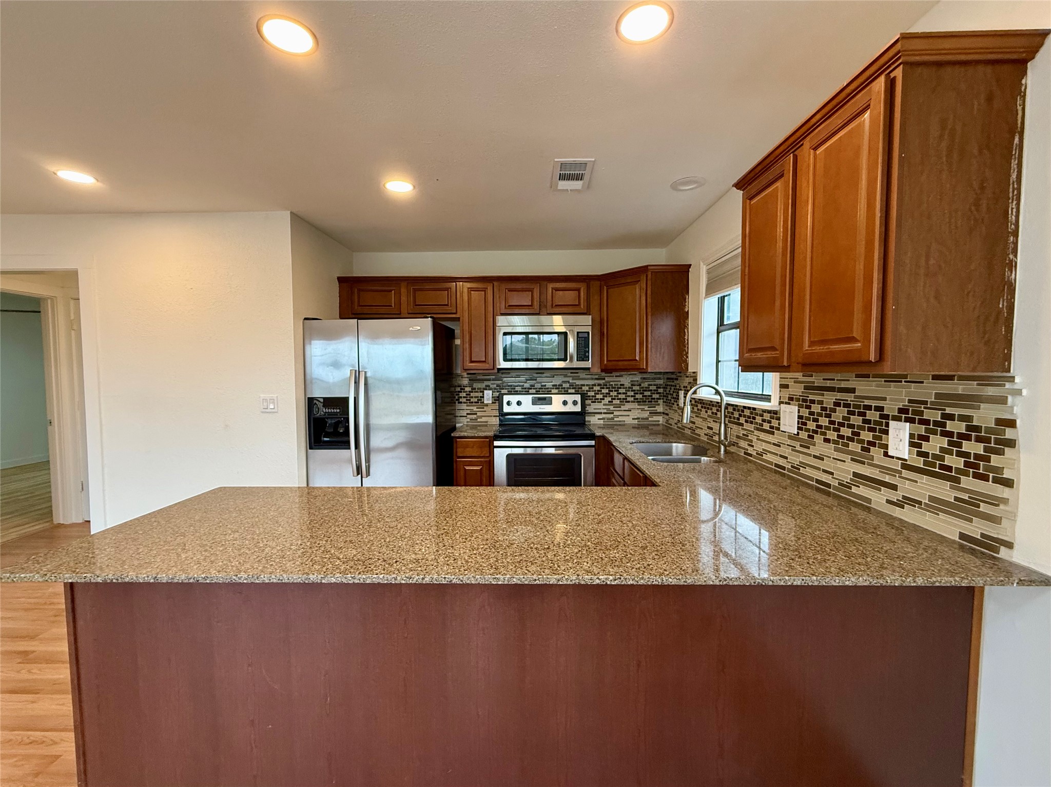 21003 Boggy Ford Road, Unit A Lago Vista, TX 78645 - Photo 5 of 19 a kitchen with stainless steel appliances granite countertop a sink a stove and a refrigerator