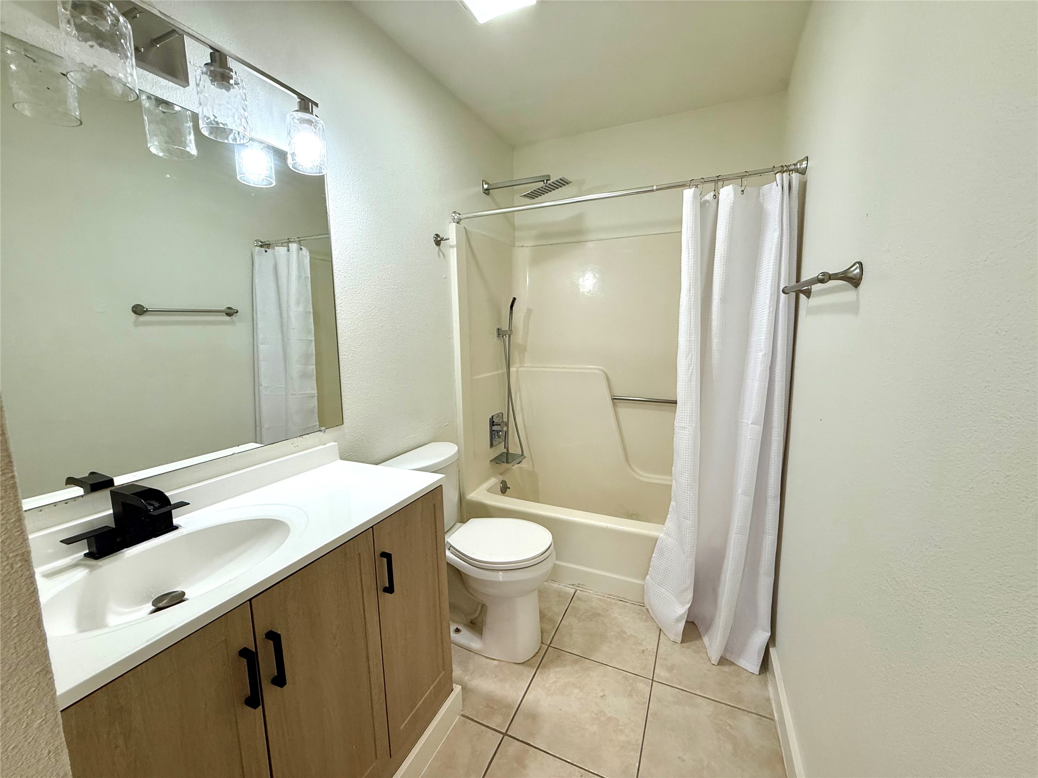 21003 Boggy Ford Road, Unit A Lago Vista, TX 78645 - Photo 7 of 19 a bathroom with a sink a toilet a mirror and shower