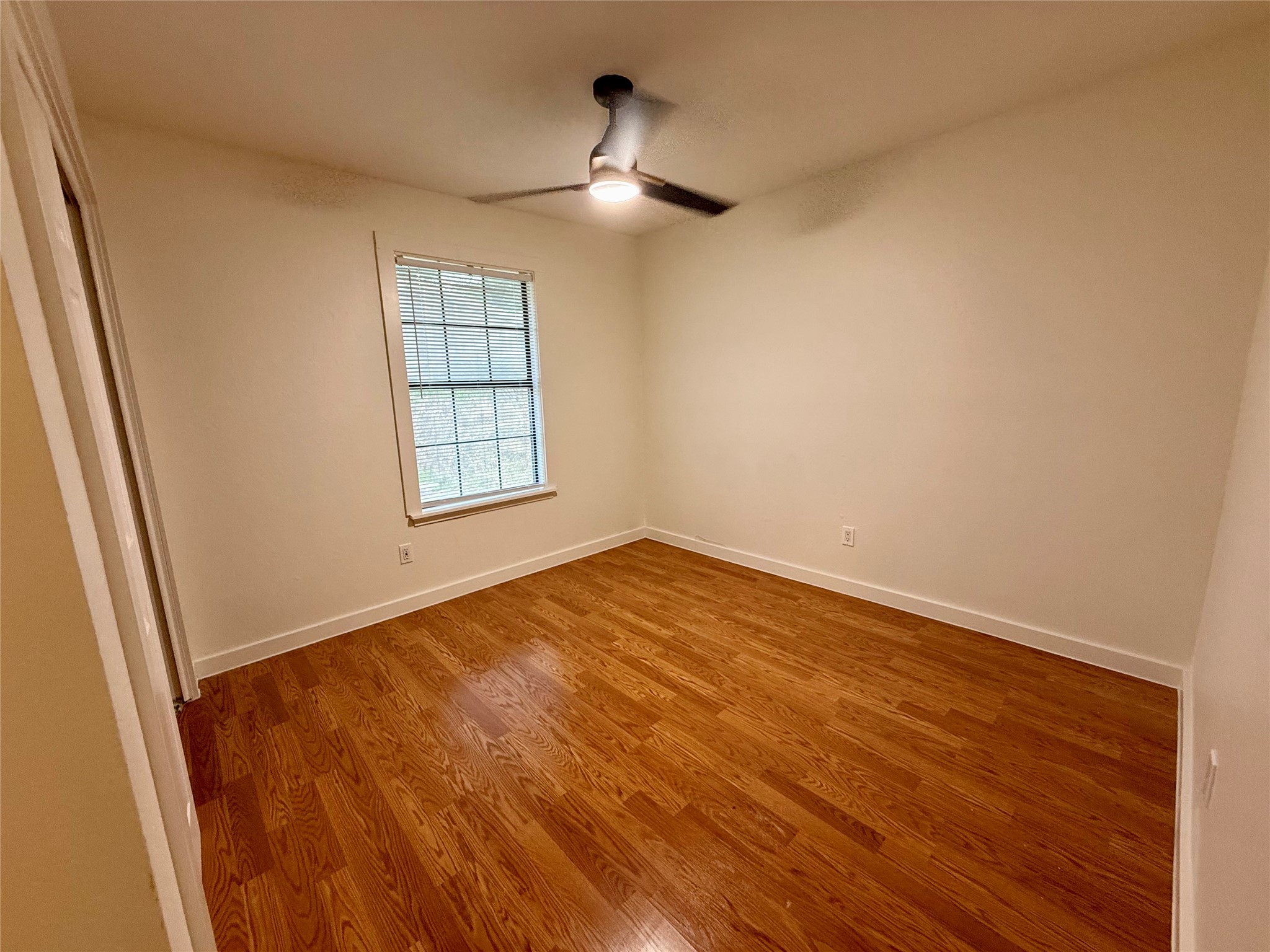 21003 Boggy Ford Road, Unit A Lago Vista, TX 78645 - Photo 8 of 19 an empty room with wooden floor cabinet and windows