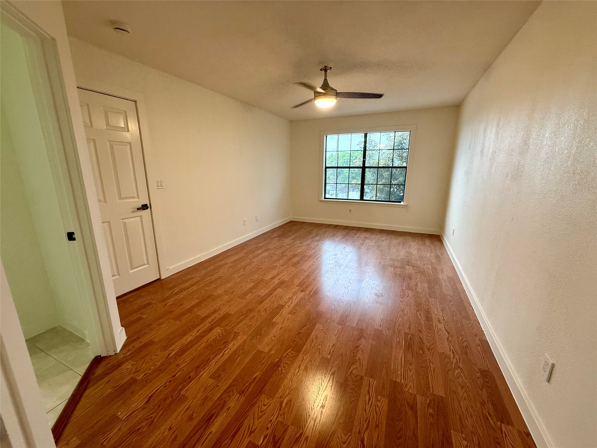 21003 Boggy Ford Road, Unit A Lago Vista, TX 78645 - Photo 10 of 19 wooden floor in an empty room with a window