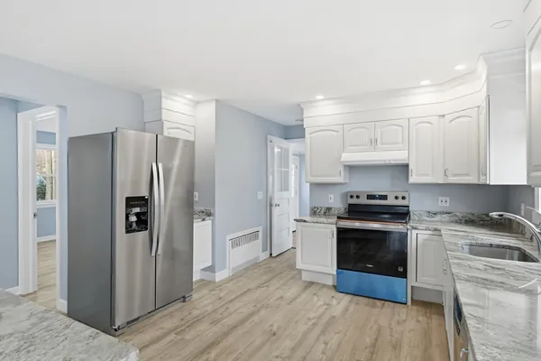 a kitchen with stainless steel appliances granite countertop a refrigerator stove and sink