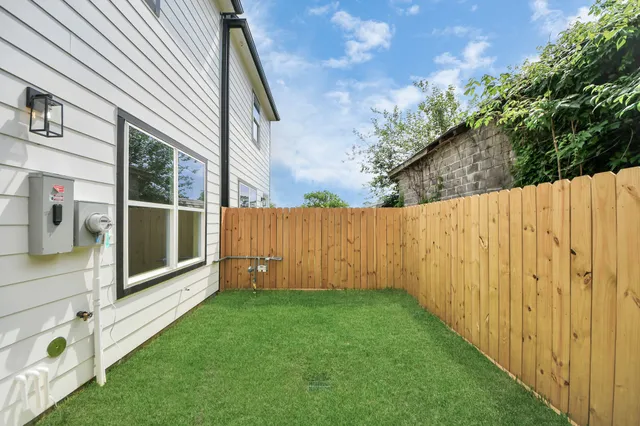 a view of a backyard with potted plants and wooden fence