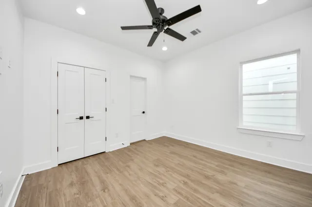 an empty room with a window and a ceiling fan
