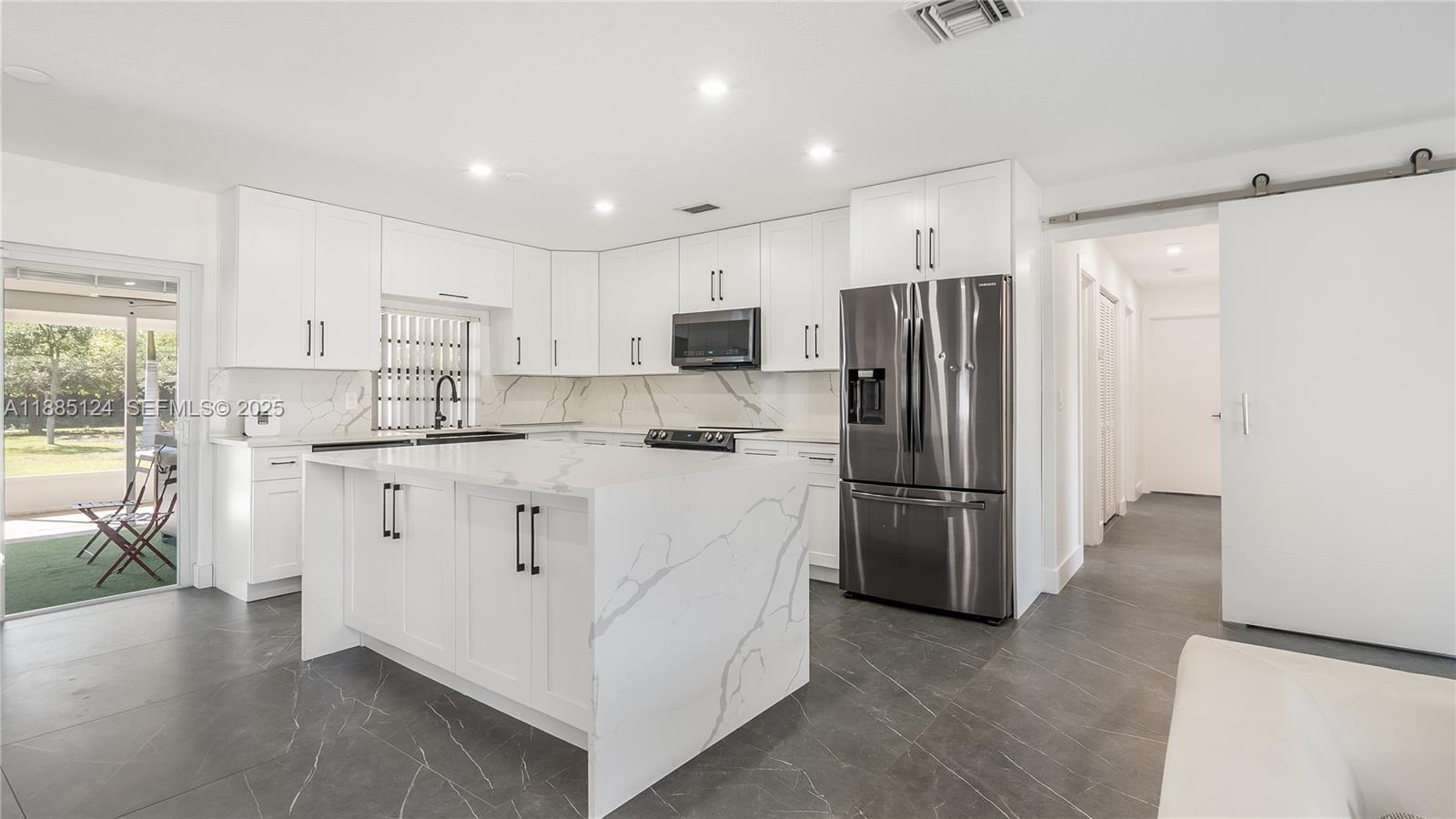 6231 Southwest 188th Avenue Southwest Ranches, FL 33332 - Photo 2 of 40 a kitchen with white cabinets and stainless steel appliances