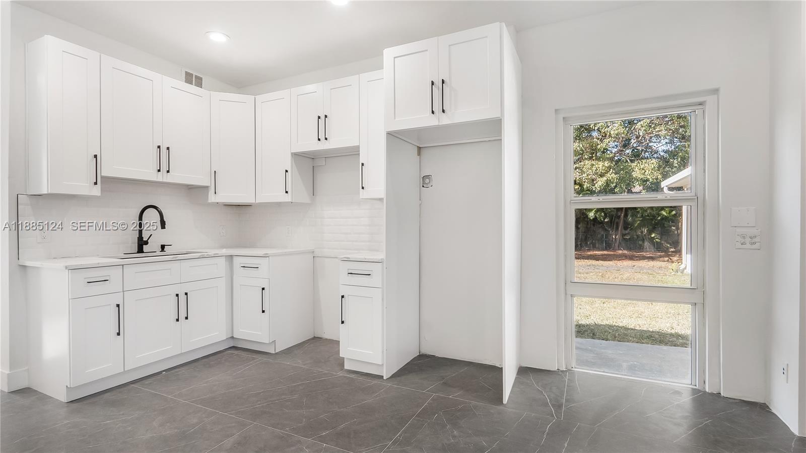 6231 Southwest 188th Avenue Southwest Ranches, FL 33332 - Photo 36 of 40 a kitchen with white cabinets and window