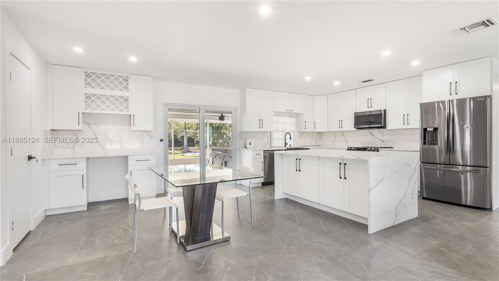6231 Southwest 188th Avenue Southwest Ranches, FL 33332 - Photo 9 of 40 a kitchen that has a lot of white cabinets and stainless steel appliances