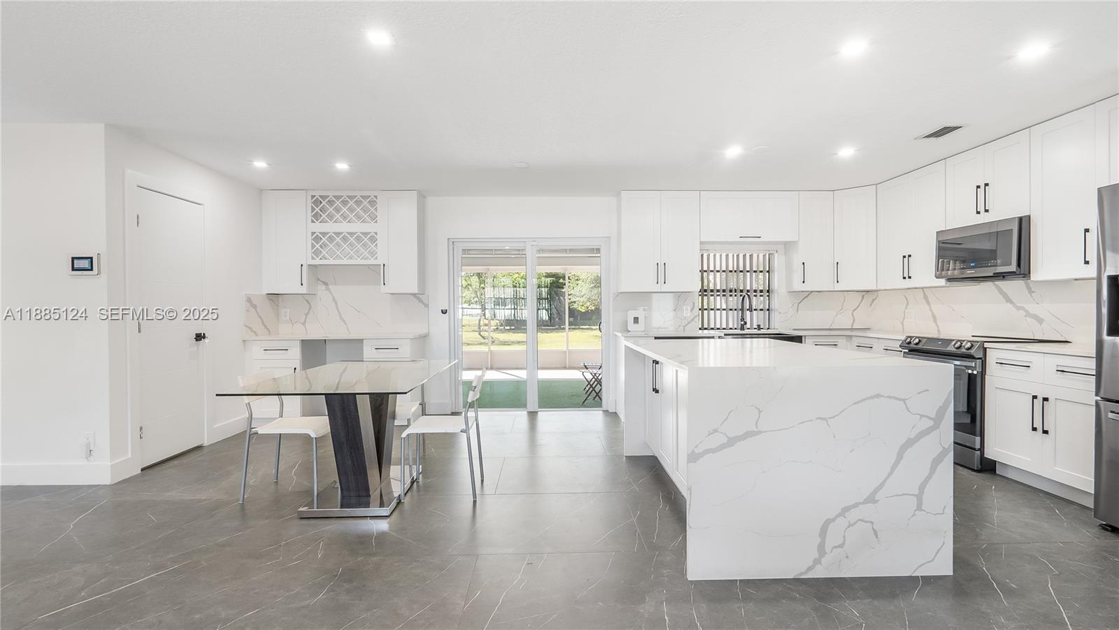 6231 Southwest 188th Avenue Southwest Ranches, FL 33332 - Photo 10 of 40 a living room with kitchen island furniture and a flat screen tv