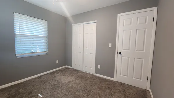 an empty room with windows and closet