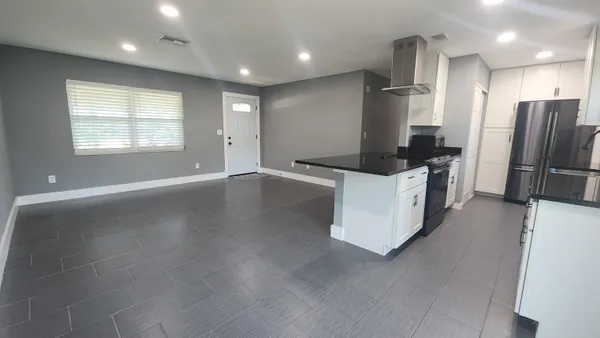 a kitchen with stainless steel appliances kitchen island granite countertop a refrigerator a sink and a stove