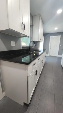 a kitchen with granite countertop a sink and a stove