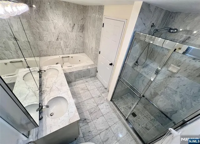 a bathroom with a granite countertop bathtub shower sink and mirror