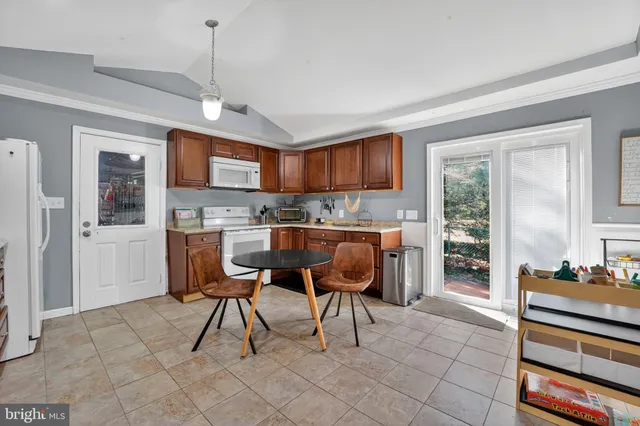 a kitchen with stainless steel appliances granite countertop a refrigerator a sink dishwasher a stove and white cabinets with wooden floor