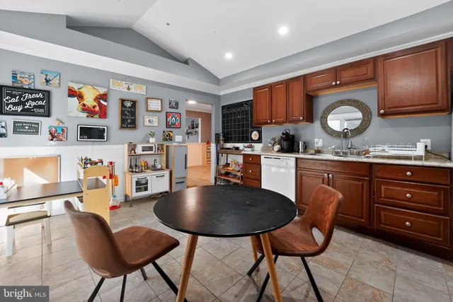 a kitchen with stainless steel appliances granite countertop a sink a stove a refrigerator cabinets and dining table