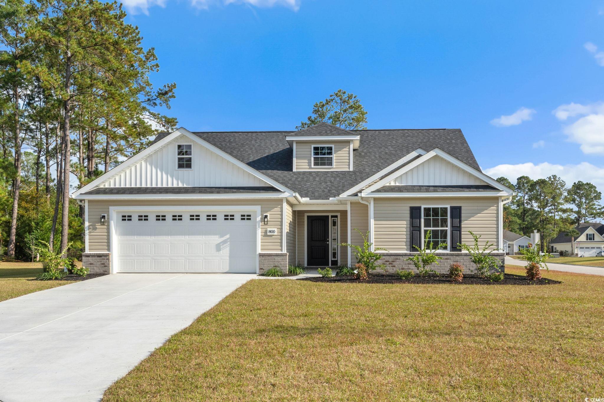 Craftsman house featuring roof with shingles, brick siding, and a front yard