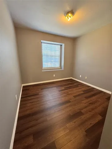 a view of room with window and wooden floor