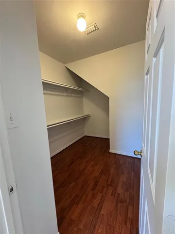 a view of a kitchen with wooden floor electronic appliances and stairs