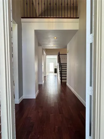 a hallway with wooden floor table and chairs