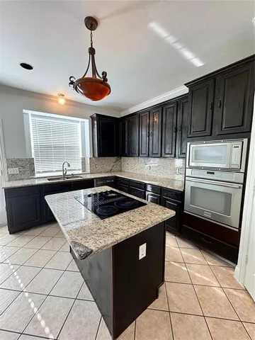 a kitchen with a stove sink and cabinets