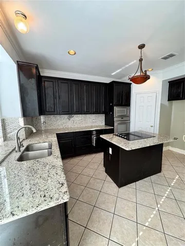 a kitchen with granite countertop a stove a sink and a microwave