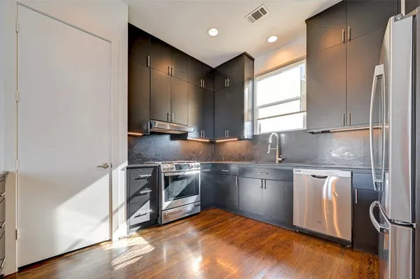 a kitchen with stainless steel appliances granite countertop a refrigerator a sink and a stove