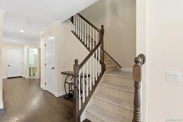 a view of a hallway with wooden floor and staircase