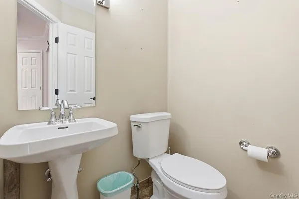 a bathroom with a toilet a sink and mirror