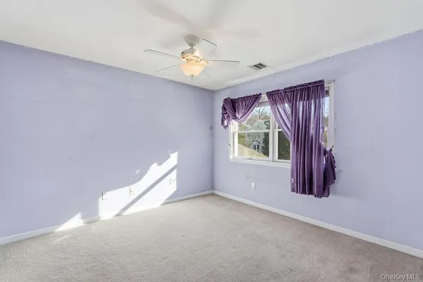 a view of a livingroom with a ceiling fan and window
