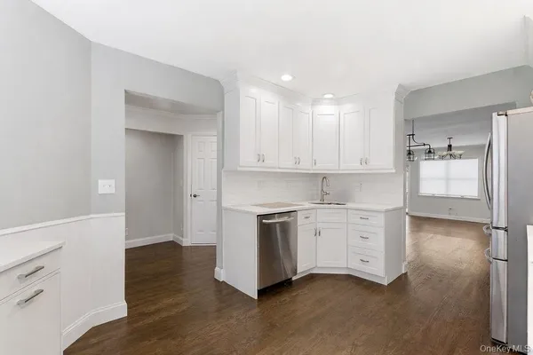 a kitchen with white cabinets and stainless steel appliances