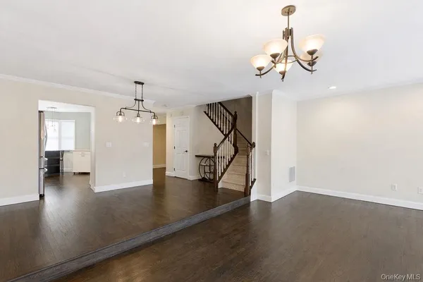 a view of a livingroom with wooden floor and a chandelier