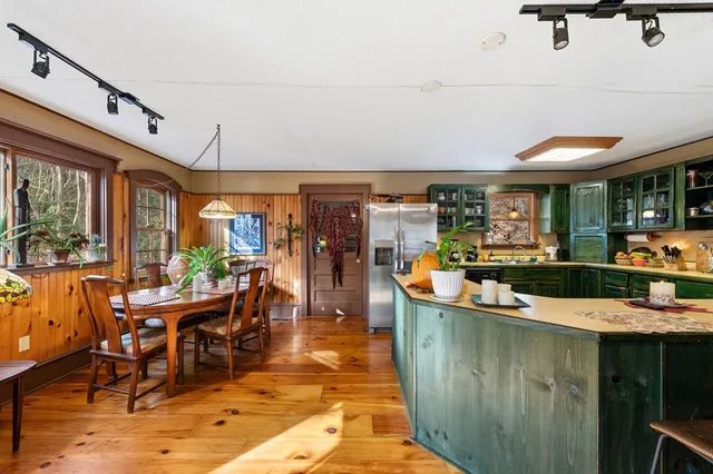 a kitchen with stainless steel appliances granite countertop a stove a sink and a dining table