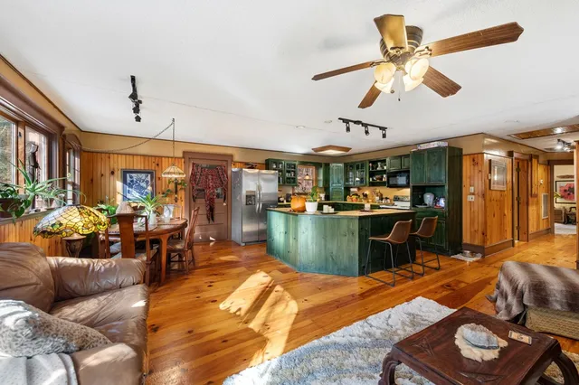 a living room with furniture kitchen view and a large window