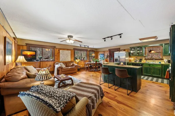 a living room with furniture a chandelier and a large window