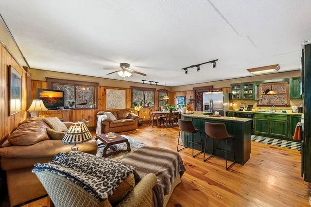 a living room with furniture a chandelier and a large window