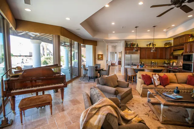 a living room with furniture kitchen area and a large window