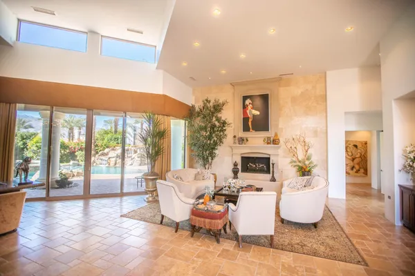 a living room with furniture a fireplace and a floor to ceiling window