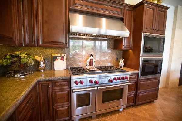a stove top oven sitting inside of a kitchen