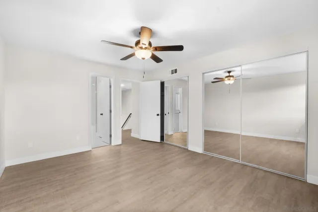 an empty room with a fan & a ceiling fan