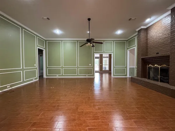 a view of empty room with wooden floor and fireplace