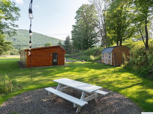 a backyard of a house with a yard and outdoor seating