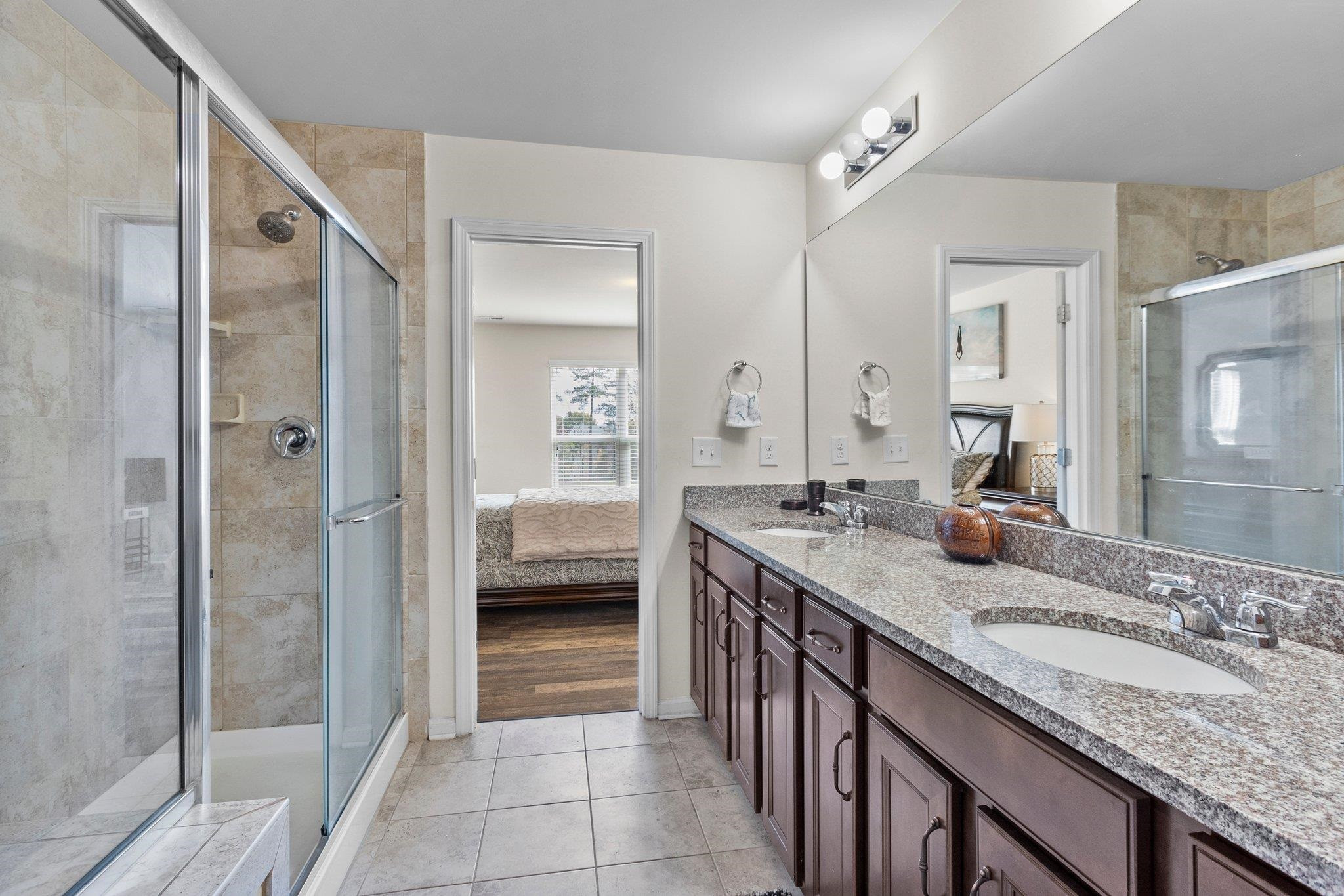 1022 Saffron Loop Durham, NC 27713 - Photo 16 of 22 a en suite bathroom with a granite countertop sink a mirror and a shower