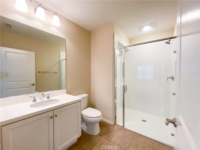 a bathroom with a shower sink vanity mirror and toilet