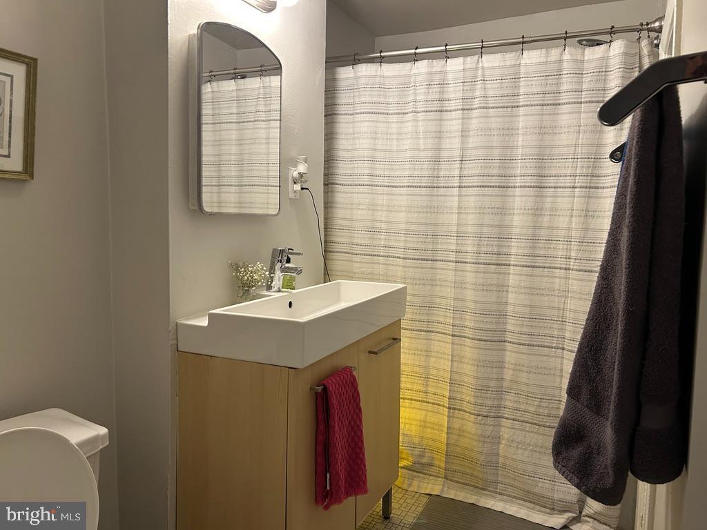 1227 Spruce Street, Unit 1R Philadelphia, PA 19107 - Photo 5 of 6 a bathroom with a sink a mirror and shower curtain