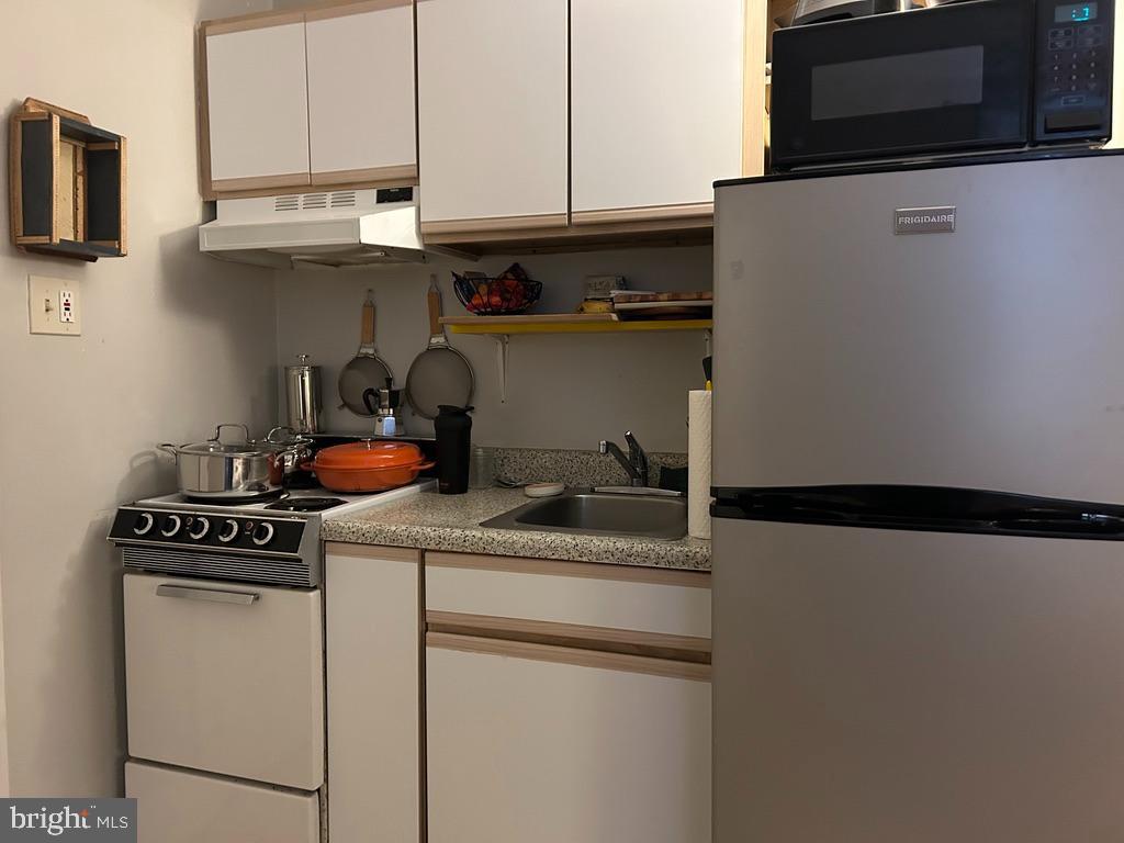 1227 Spruce Street, Unit 1R Philadelphia, PA 19107 - Photo 6 of 6 a kitchen with stainless steel appliances granite countertop a sink stove and microwave
