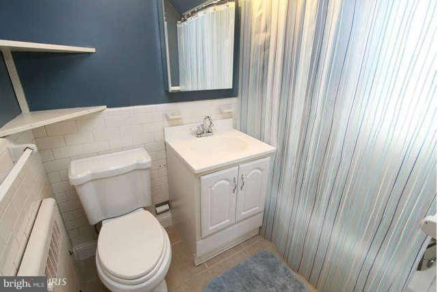 1200 Poplar Hill Road Baltimore, MD 21210 - Photo 11 of 18 a white toilet sitting next to a bathroom sink