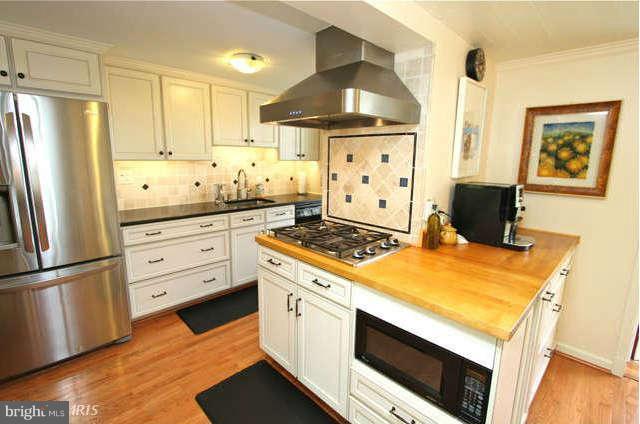 1200 Poplar Hill Road Baltimore, MD 21210 - Photo 5 of 18 a kitchen with stainless steel appliances a stove a refrigerator and white cabinets