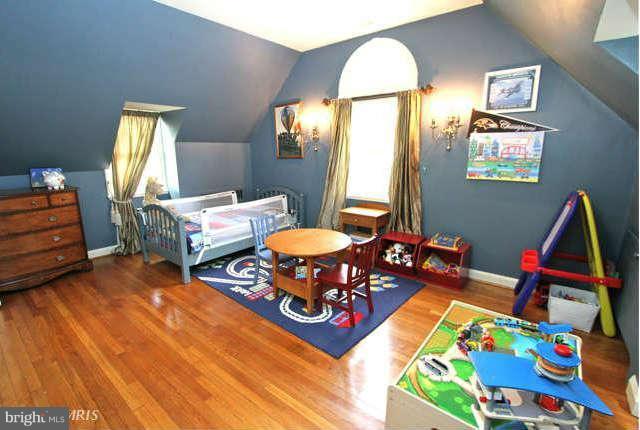 1200 Poplar Hill Road Baltimore, MD 21210 - Photo 10 of 18 a living room with baby crib furniture and a wooden floor