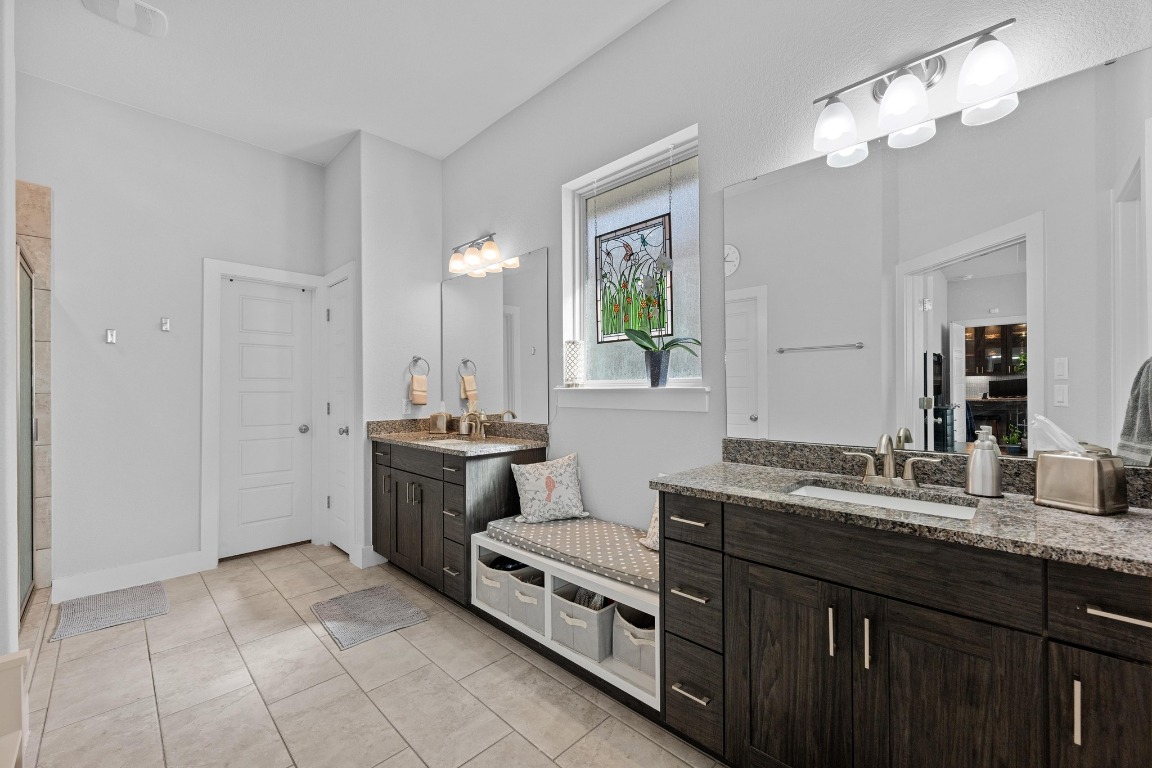217 Palio Place Georgetown, TX 78628 - Photo 14 of 40 a spacious bathroom with a granite countertop double vanity sink a mirror and a bathtub
