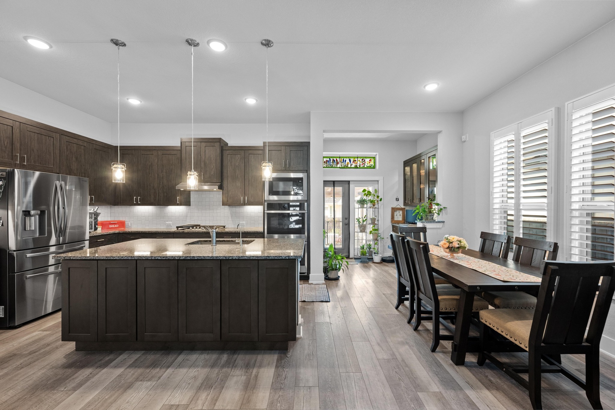 217 Palio Place Georgetown, TX 78628 - Photo 6 of 40 a kitchen with stainless steel appliances kitchen island granite countertop a table chairs stove and refrigerator