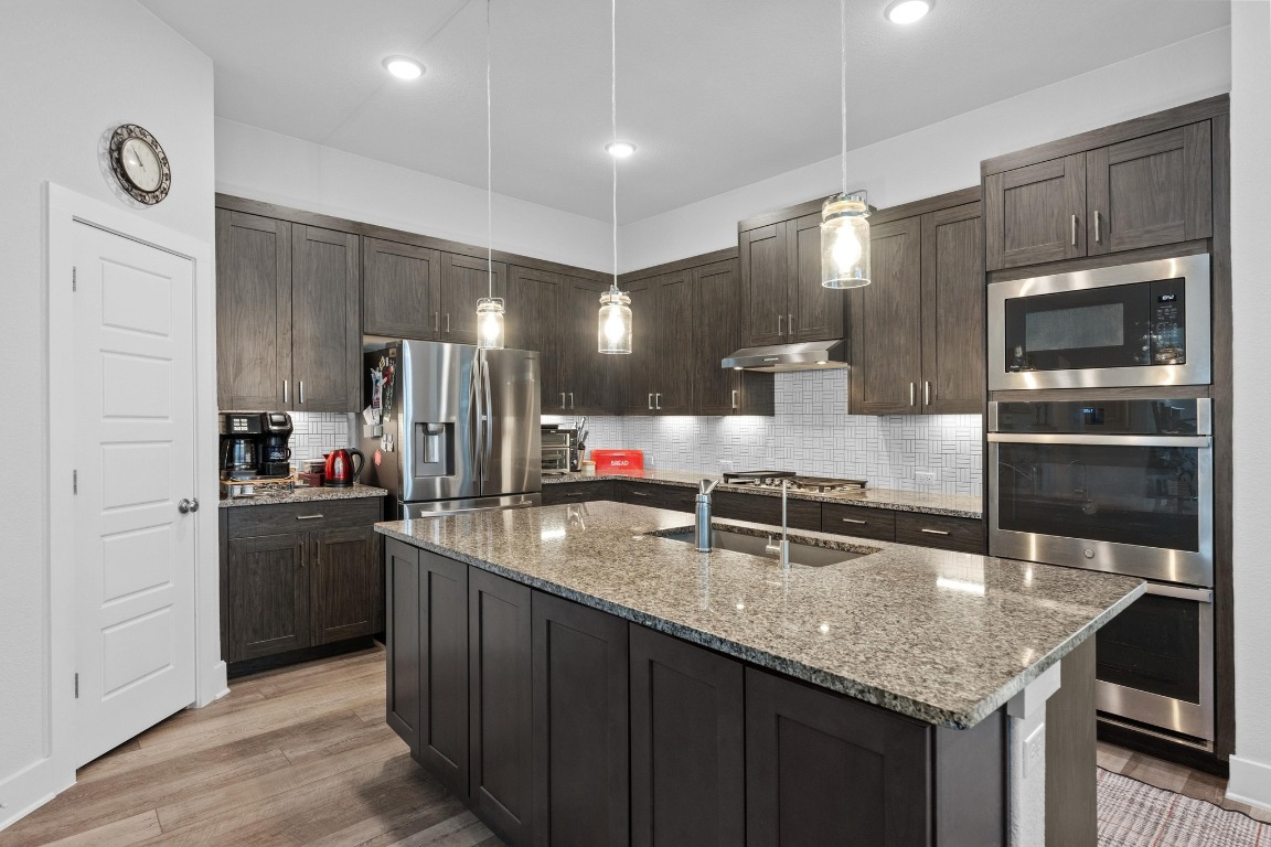 217 Palio Place Georgetown, TX 78628 - Photo 9 of 40 a kitchen with stainless steel appliances granite countertop a sink a stove and a refrigerator