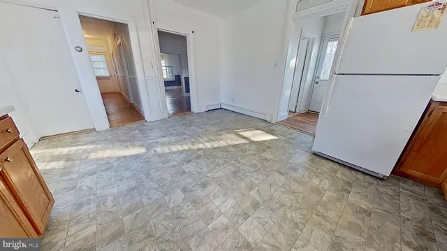 a view of a kitchen with refrigerator and front door